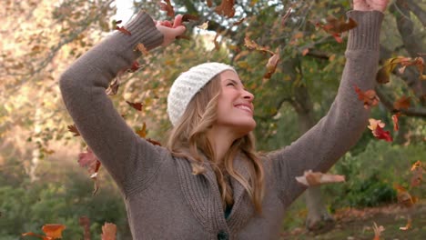 happy woman throwing leaves around