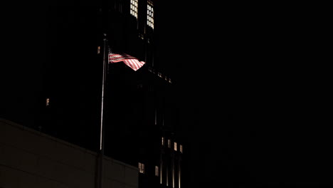 american flag waving on top of a manhattan building