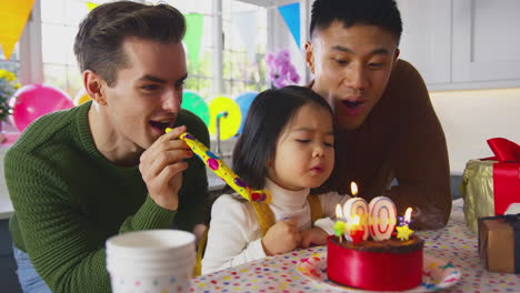 두 아빠와 딸이 있는 가족은 부모의 30번째 생일을 케이크와 파티 플로어와 함께 집에서 축하합니다.