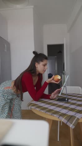 woman inspecting apple in the kitchen