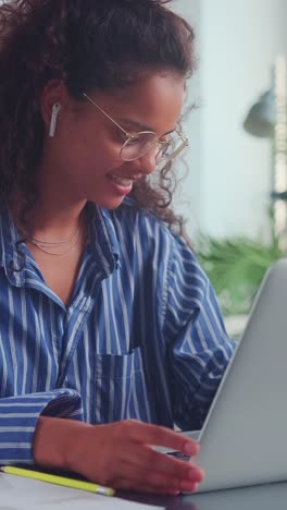young positive indian woman making video call through laptop sits in library