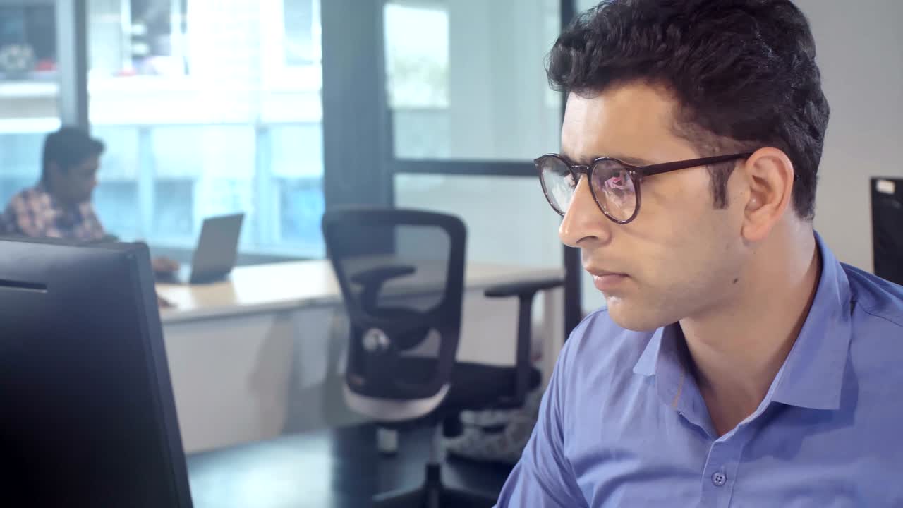 joven miembro del personal con gafas concentrado y trabajando duro