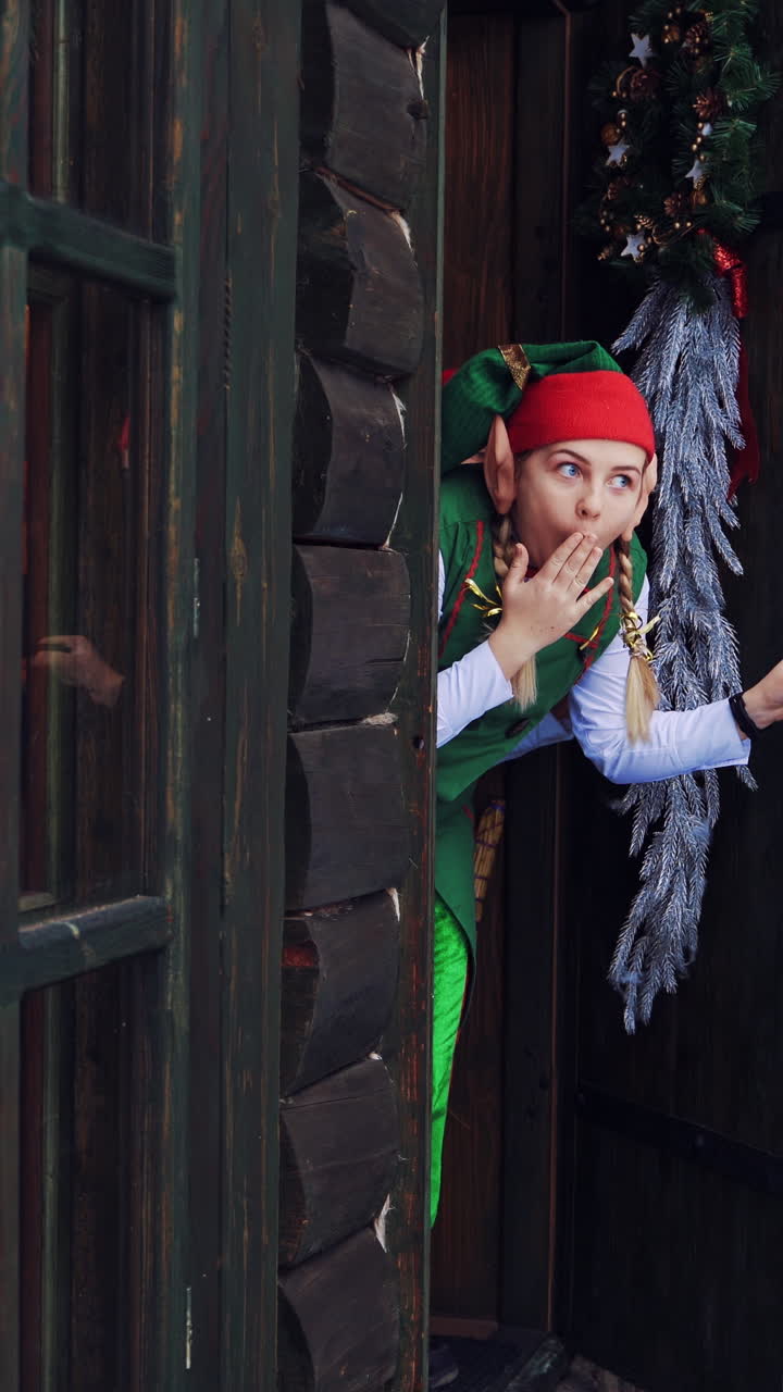 Christmas Elves Peeking from a Wooden Cabin Door