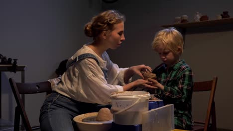 woman helps boy to sculpt in the workshop