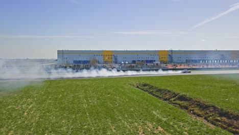 car tire smoke on a race track from aerial view on a finish path of a race map with a driftin attitude