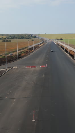 newly paved highway with street lights and distant vehicles
