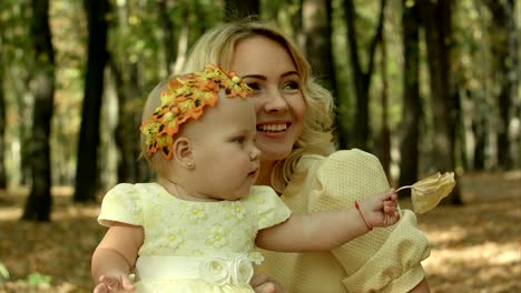 young mother with her baby daughter in autumn park