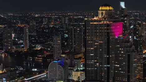 cinematic drone shot of bangkok at night showing glowing skyscrapers, city lights, and river reflections. stunning aerial view of thailand's capital