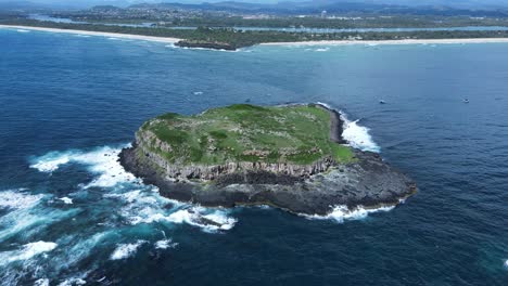 Olas-Rompiendo-Contra-Una-Isla-Deshabitada-Rodeada-De-Aguas-Azules-Profundas