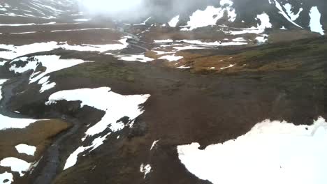 captured by a high-resolution 4k drone, featuring stunning aerial and cinematic shots of an icelandic mountaintop enveloped in snow and misty conditions