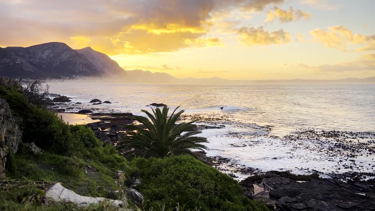 Vista vivida dell'alba mattutina dalla scogliera costiera di Hermanus sull'oceano e sulla baia di Walker.