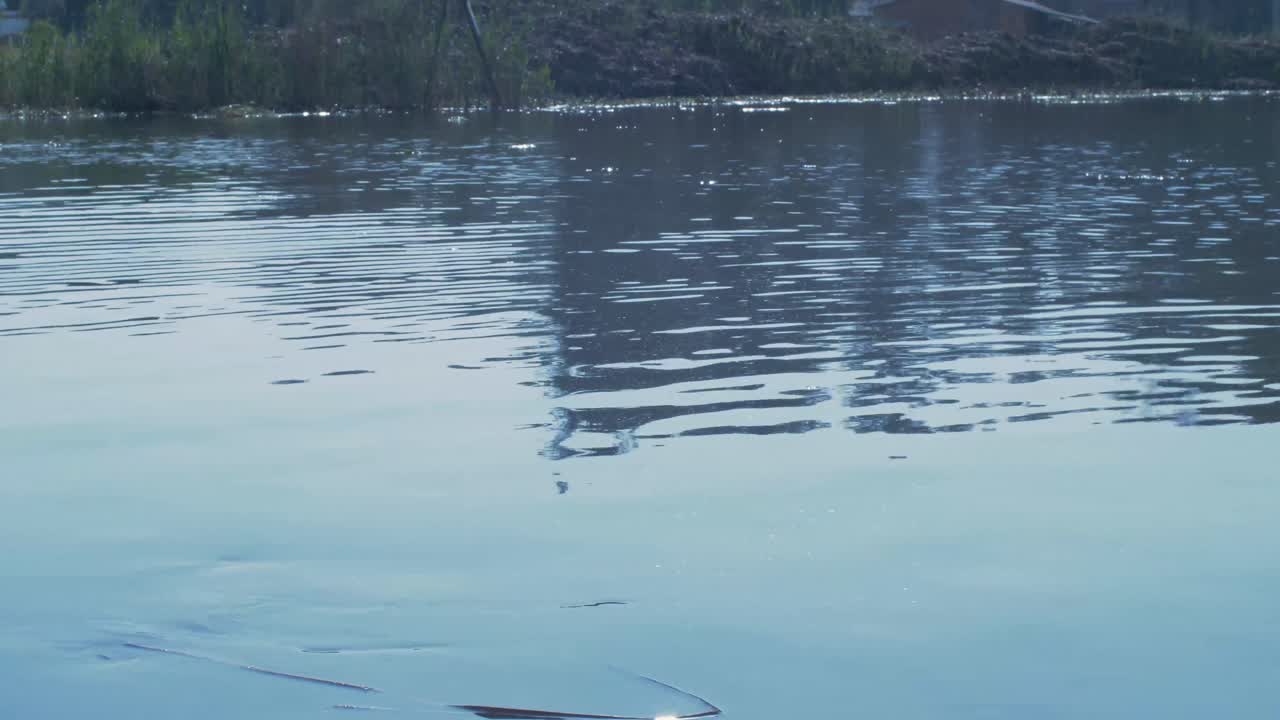 A polo ball splashing into a dam  at sunset