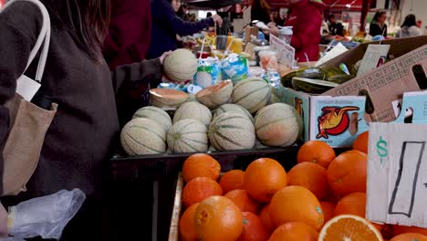 person selecting fruit at a market stall