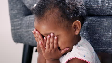 cute baby girl playing peek a boo at home