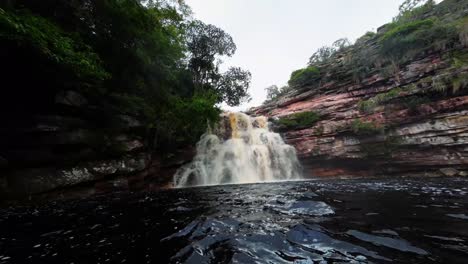 Una-Cámara-De-Acción-Extremadamente-Ancha-Nadando-Dentro-Del-Impresionante-Lago-Del-Pozo-Del-Diablo-Con-Una-Gran-Cascada-En-El-Hermoso-Parque-Nacional-Chapada-Diamantina-En-El-Noreste-De-Brasil-En-Un-Día-Nublado