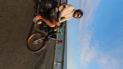 happy biker travelling along the scenic coastal roads of vietnam, southeast asia. beautiful sunset casting a natural glow on the subject.