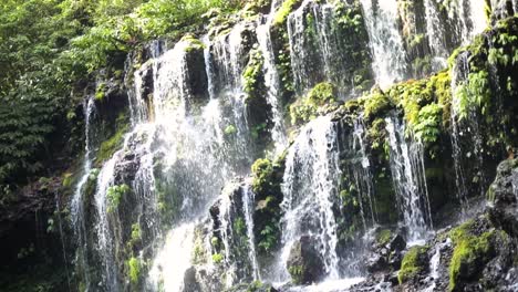 Slow-Motion-Shot-of-one-of-the-many-beautiful-Banyu-Wana-Amertha-Waterfalls-gushing-off-of-the-mountain-in-the-jungles-of-Bali,-Indonesia