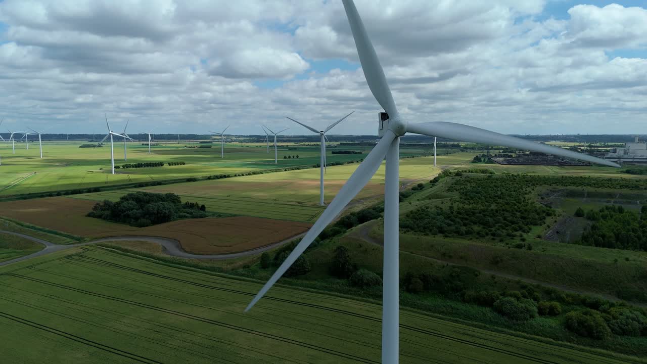 Turbine Towers Spinning in Rural Fields, England — Aerial Drone video