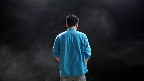 hombre de camisa azul vista trasera en el estudio ahumado