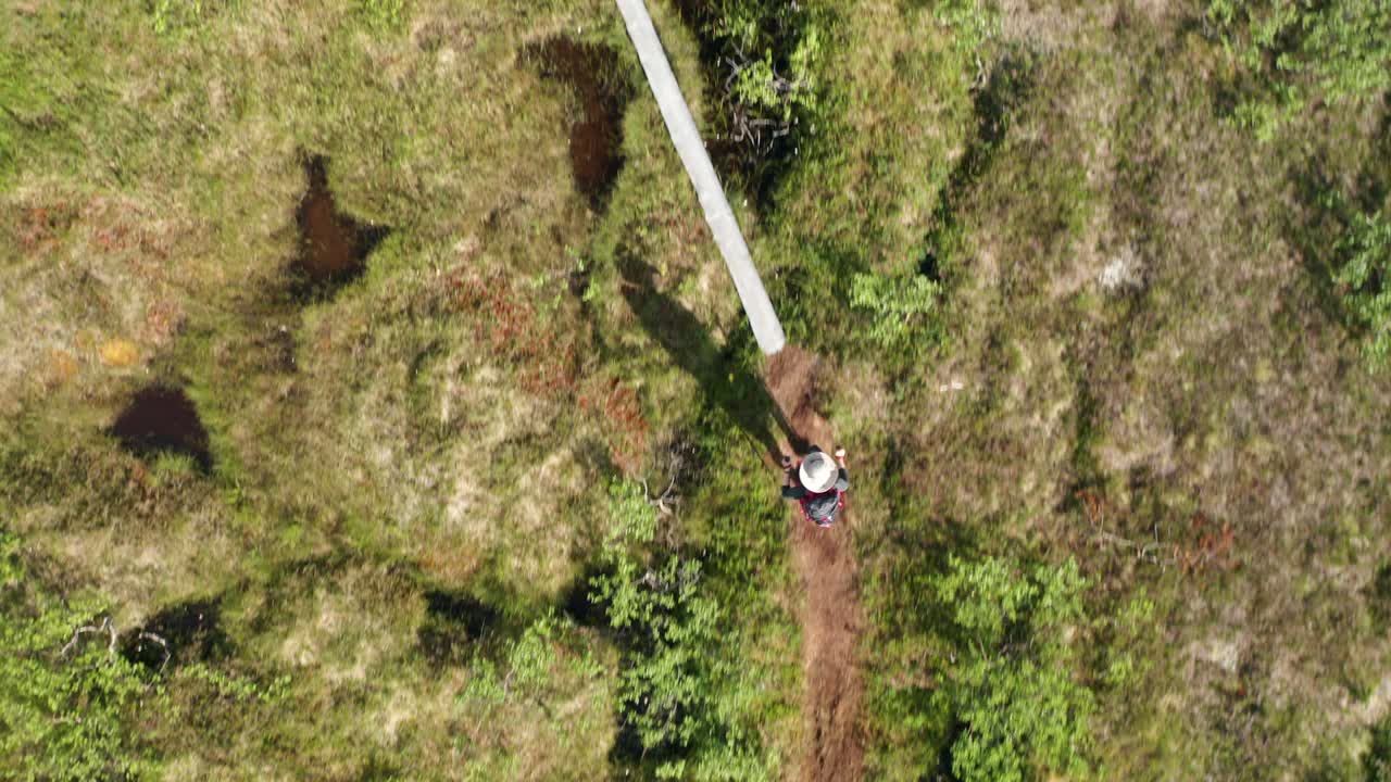 una vista aérea de una excursionista caminando por un sendero