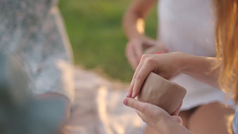 las niñas se dedican al modelado de arcilla en la naturaleza en el parque en el espacio abierto. clases creativas en grupo de entrenamiento en el modelado de argila. las manos de las mujeres son moldeadas a partir de arcilla de primer plano