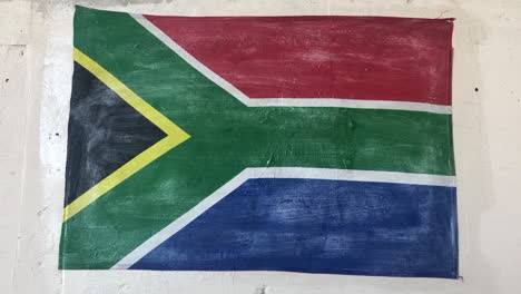 Toma-De-Mano-De-Una-Bandera-Nacional-Pintada-A-Mano-De-La-República-De-Sudáfrica-En-Una-Pared-Blanca-En-Un-Día-Soleado-De-Verano