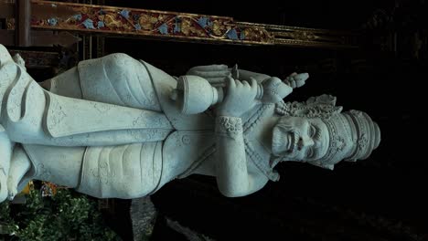 vertical slow motion dolly shot of a sacred sculpture at pura tirta empul temple on bali in ubud indonesia during an adventurous and interesting journey through history