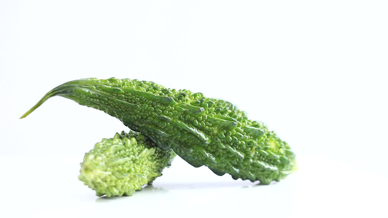 흰색 배경 측면 샷에서 회전하는 두 개의 전체 녹색 여주