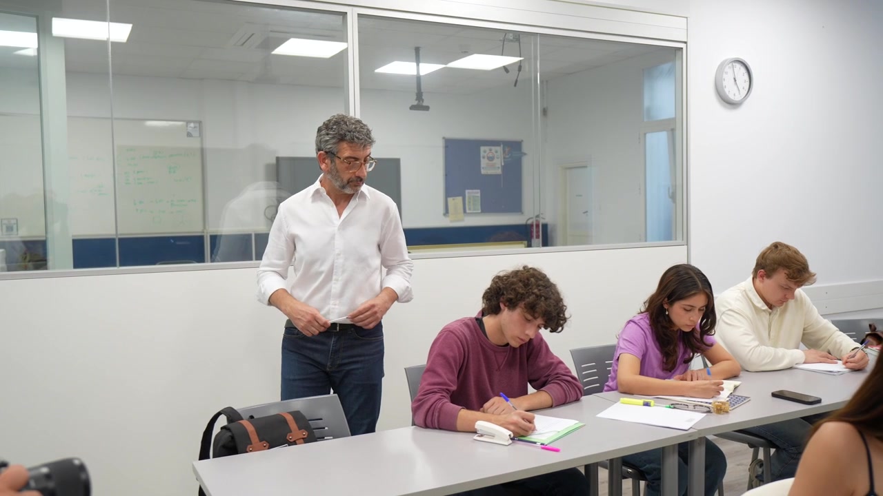 Teacher Observing Students Taking Notes in a Bright Classroom