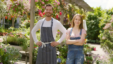 Outdoors-shot-of-cheerful-male-and-female-gardeners-looking-at-camera