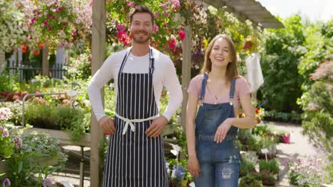 outdoors shot of cheerful male and female gardeners looking at camera