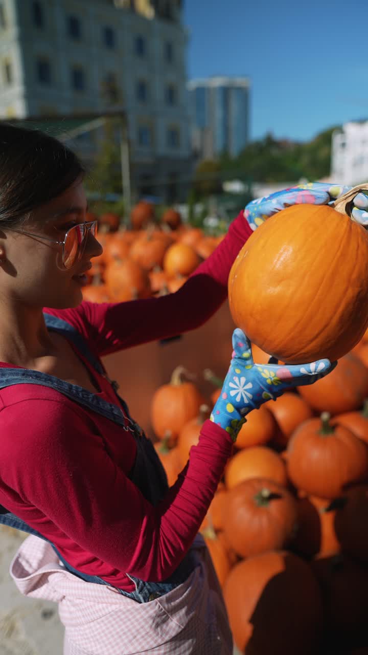 mujer recogiendo una calabaza en un parche de calabaza