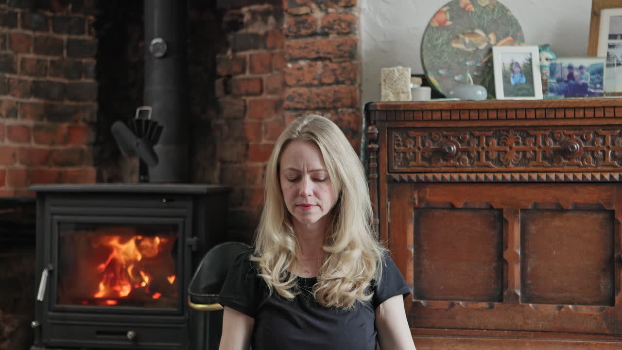 Woman doing yoga near fireplace