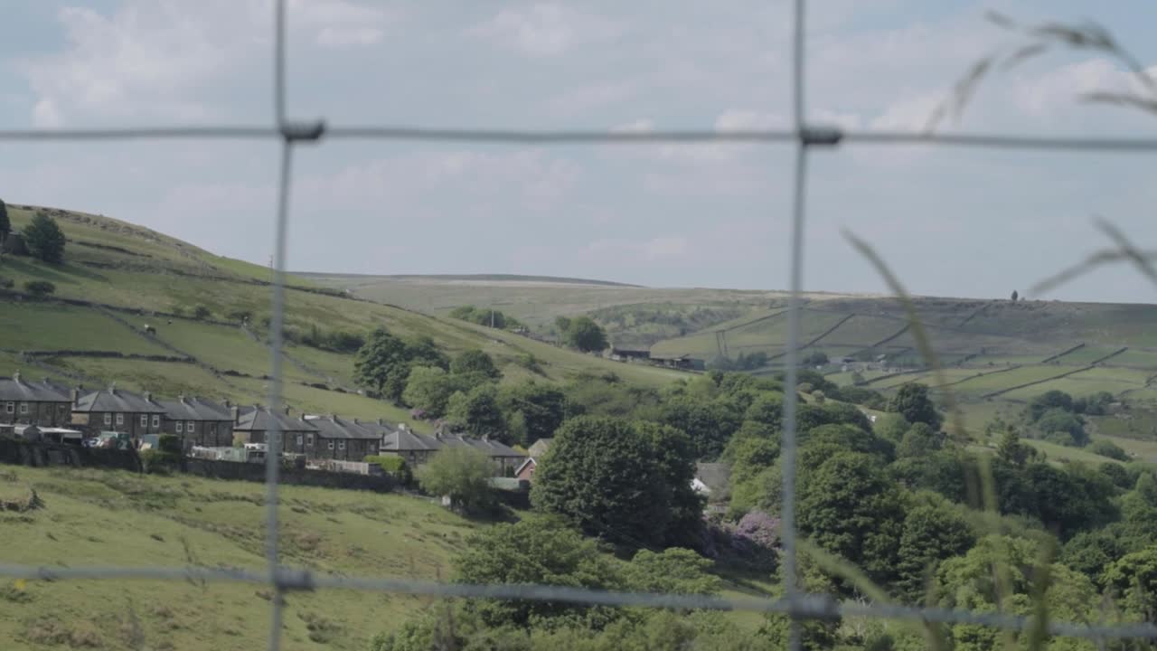 Yorkshire countryside hills wide tilting shot through fence