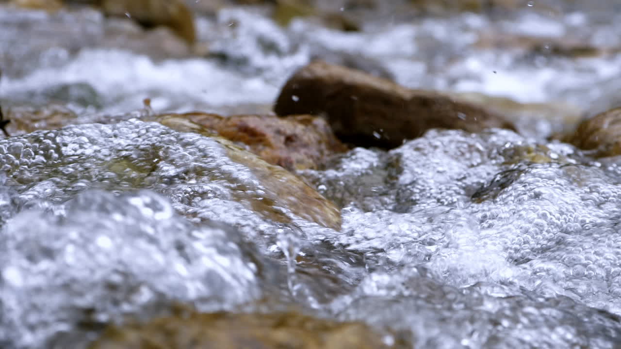 Ruscello limpido che scorre tra massi di pietra. Fiume copioso che scorre al rallentatore.
