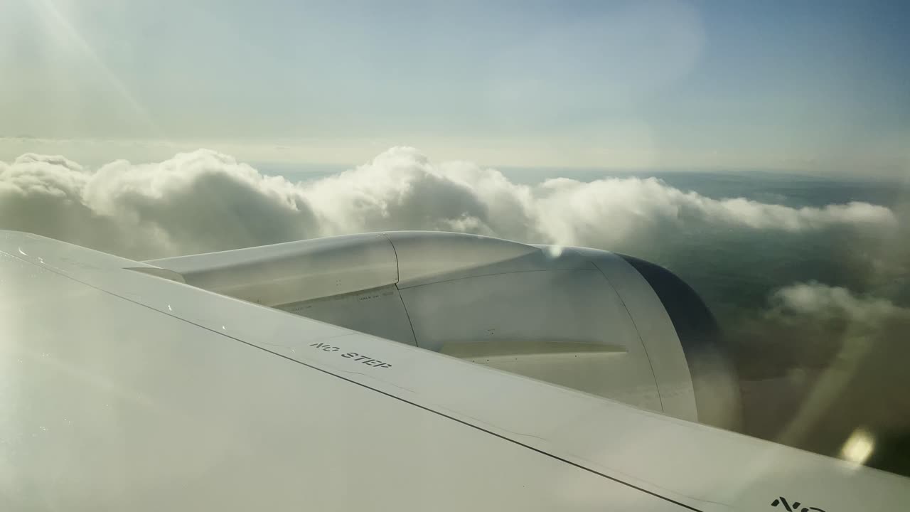 Utsikt til skyer som passerer under en kommersiell Boeing-flygning på himmelen