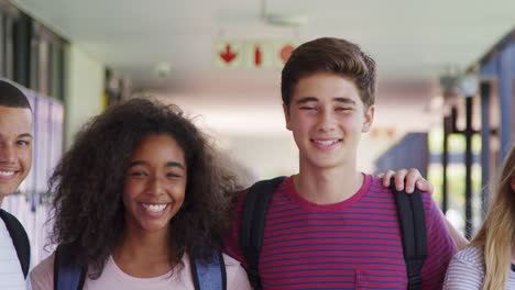 teenage classmates standing in high school hallway, close up