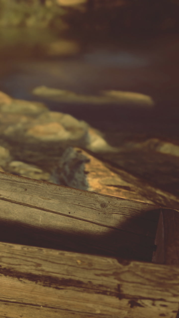 Wooden box near riverbank at sunset with reflections on water