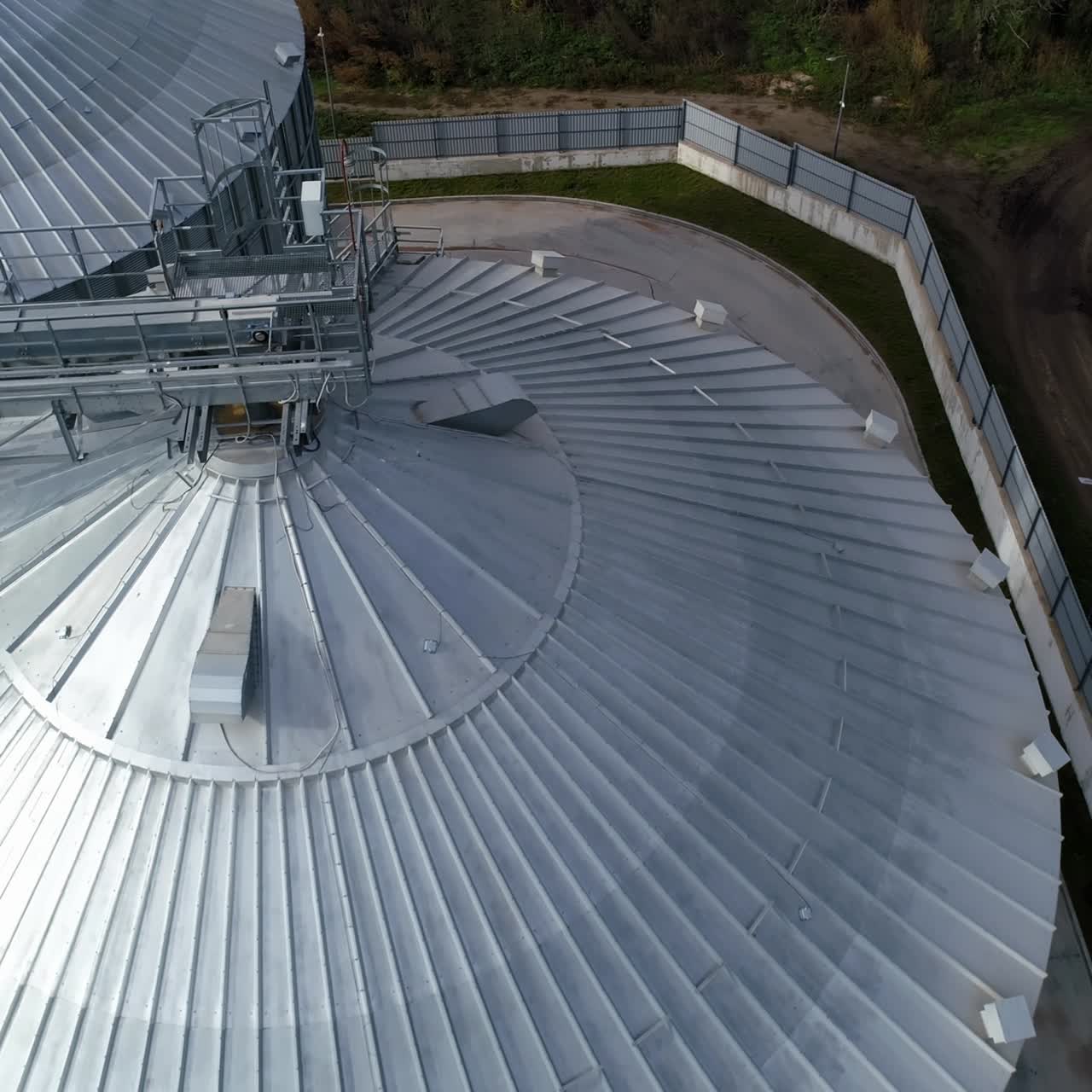 Metal constructions on the top of grain elevators. Modern industry for storage agricultural products. Silver granaries for agribusiness. Top aerial view