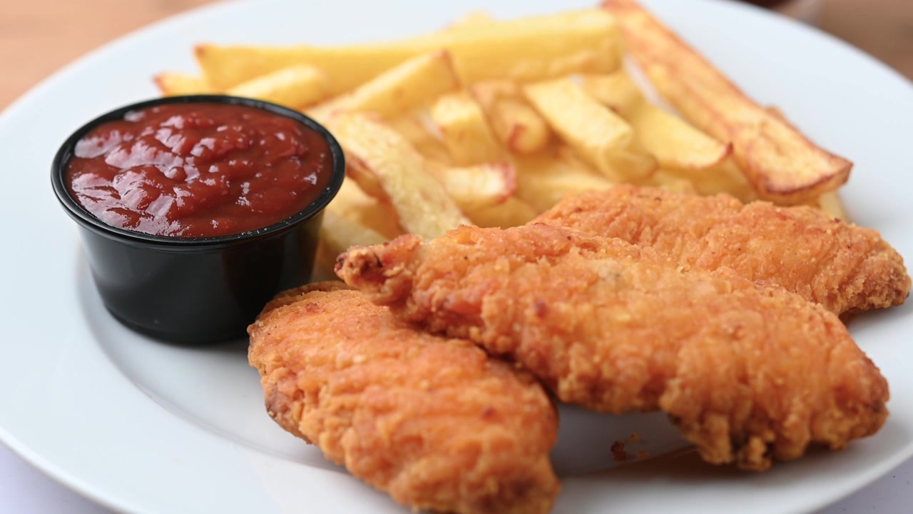 Crispy Fried Chicken Tender con patatine fritte e ketchup