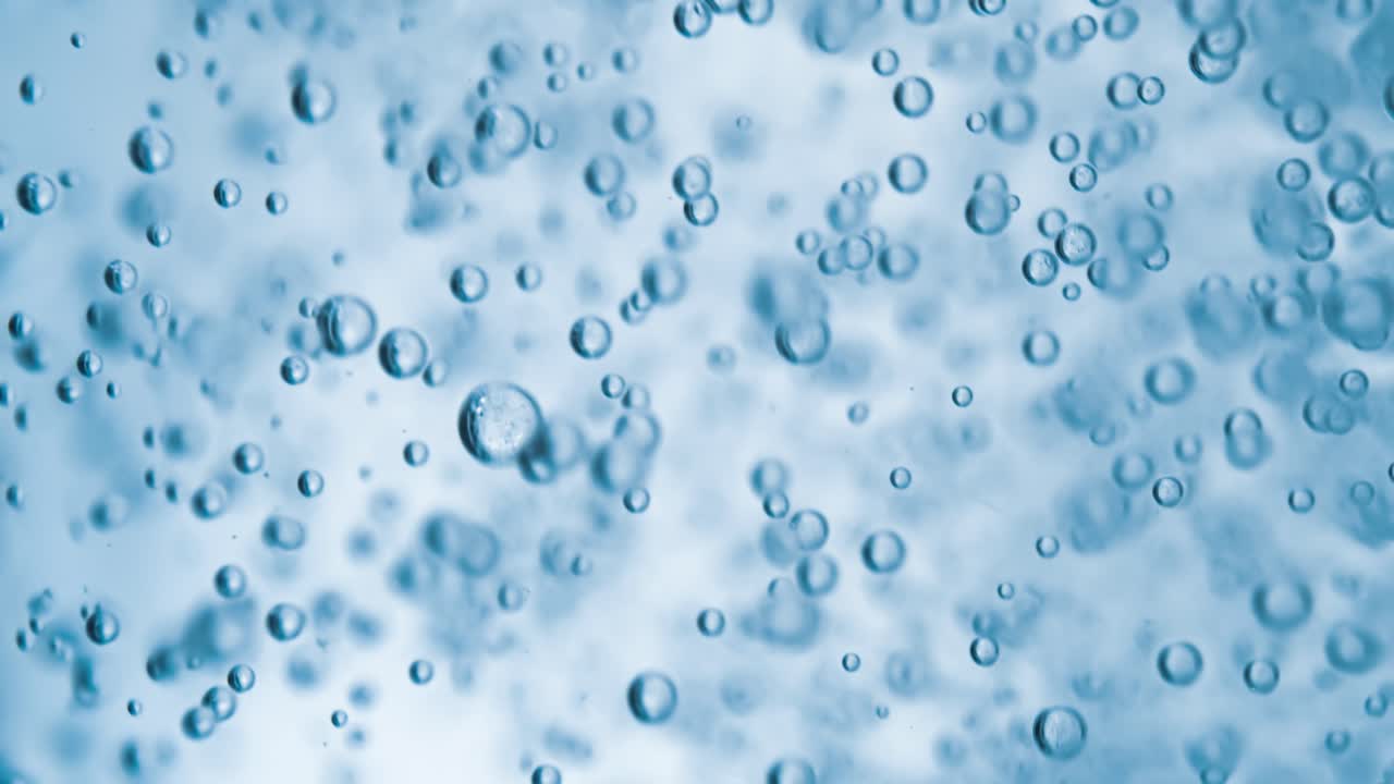 Molte bolle d'acqua in primo piano in acqua blu, onda d'acqua astratta con bolle al rallentatore