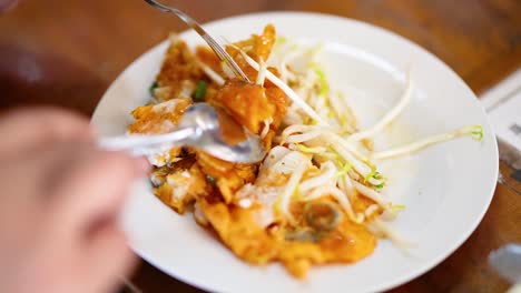 hands savoring a mussel pancake with utensils