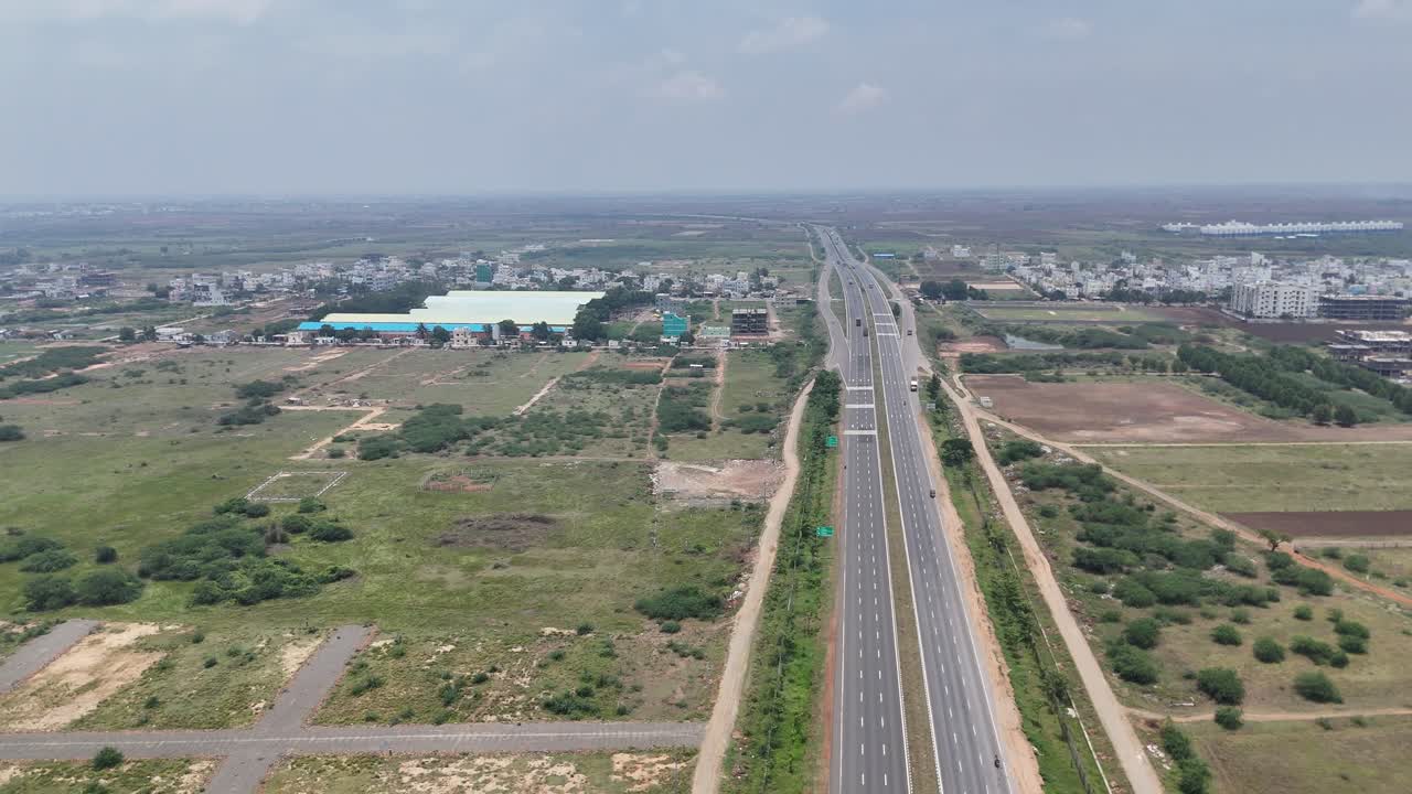 Panoramic view of factories and smokestacks with a hazy skyline in Hyderabad.