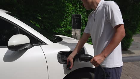 Progressive-man-install-cable-plug-to-his-EV-car-from-home-charging-station.