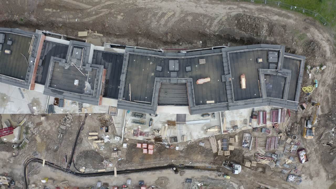 вид сверху на строительную площадку с недостроенными жилыми домами