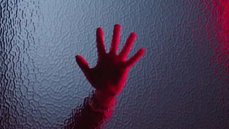 hand sliding down window dying in red light murder concept