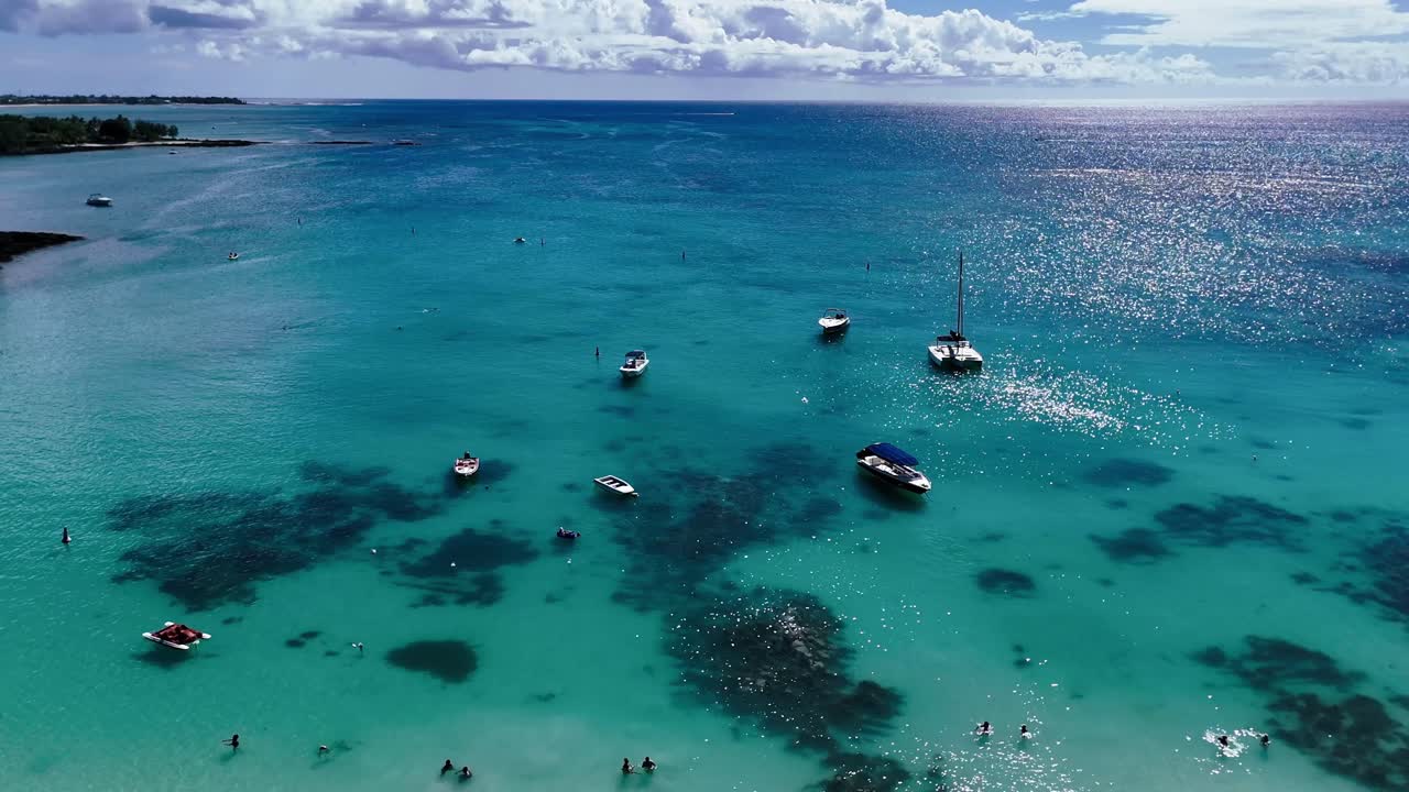 Aerial view of Pereybere Beach, Mauritius, with yachts and swimmers in vibrant turquoise waters, perfect for showcasing tropical serenity and ocean leisure scenes.