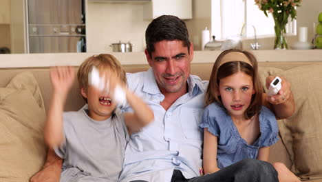 Cute-children-playing-video-games-with-their-father-on-the-sofa