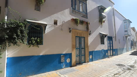 white and blue traditional tunisian house with ornate windows on a sunny day