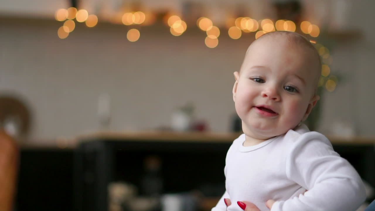 una niña linda jugando con su hijo en la cama. una madre joven jugando con un bebé en la cama.